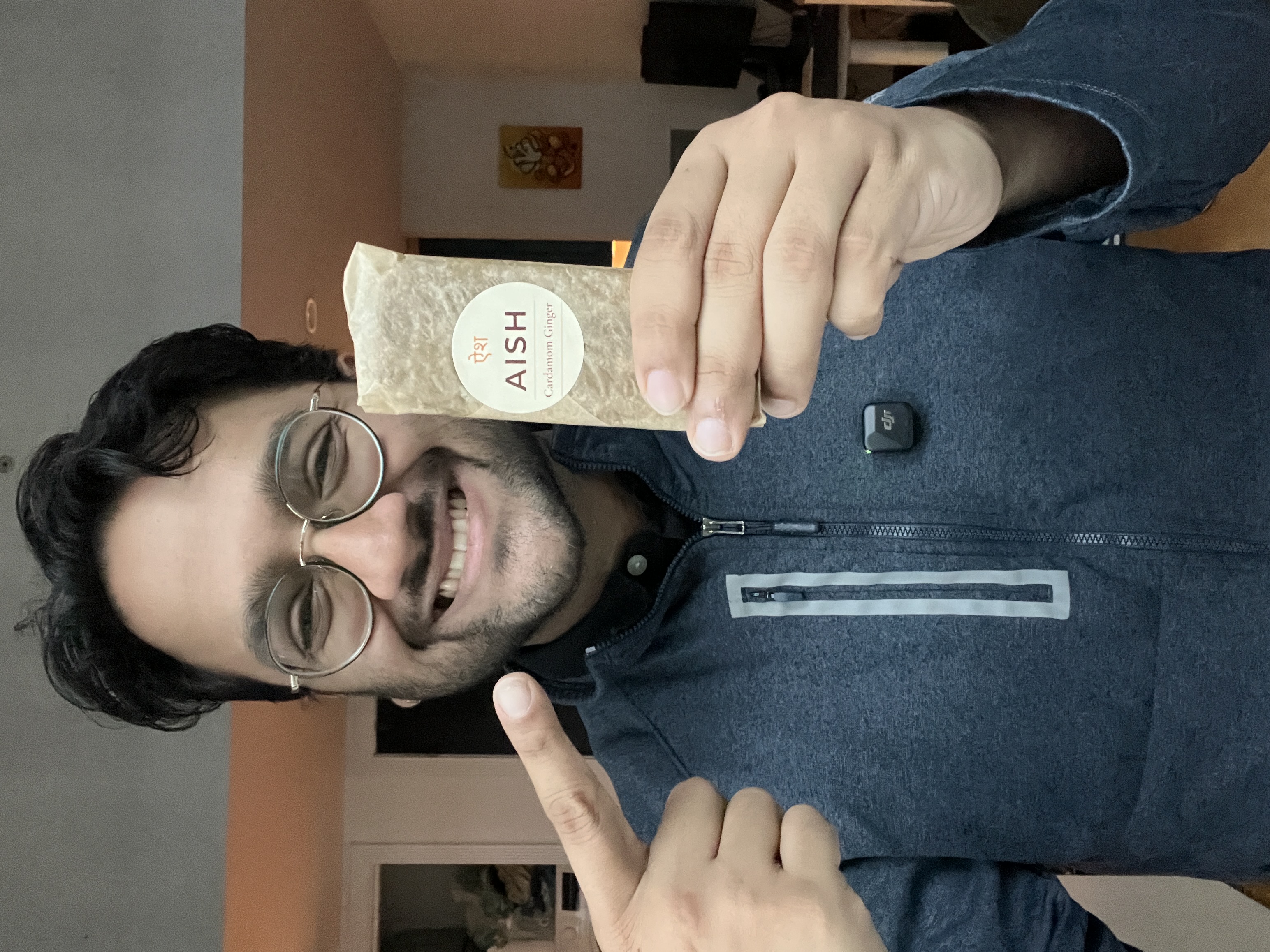 Abhi holding an AISH Cardamom Ginger protein bar